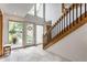 Bright foyer with large windows, tiled floors, a wooden staircase, and a view to the home's exterior at 5326 White Marsh Ln, Indianapolis, IN 46226