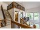 Bright foyer featuring a staircase with wood railings, large windows, and a view of the home's upper level at 5326 White Marsh Ln, Indianapolis, IN 46226