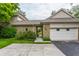 Attached two-car garage with stone detailing, well-kept lawn, and paved driveway at 5326 White Marsh Ln, Indianapolis, IN 46226