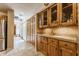 Bright kitchen with custom wood cabinets, granite countertops, and tile flooring leading to a naturally lit hallway at 5326 White Marsh Ln, Indianapolis, IN 46226