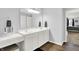 Bright bathroom featuring dual sinks, modern vanity with make up station, and wood look flooring at 5420 Orwell Ct, Indianapolis, IN 46239