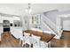 Dining area with a wooden table and white chairs, open to a kitchen with white cabinets and stainless steel appliances at 5420 Orwell Ct, Indianapolis, IN 46239