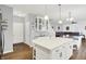 Open concept kitchen featuring island with seating, white cabinetry, and view into dining/living areas at 5420 Orwell Ct, Indianapolis, IN 46239