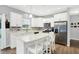 Modern kitchen with white cabinets, stainless steel appliances, an island with seating, and stylish backsplash at 5420 Orwell Ct, Indianapolis, IN 46239