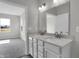 Bathroom featuring a double sink vanity flows into bedroom with carpet and natural light at 633 Bridgeman Rd, Avon, IN 46123