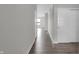 Hallway features wood flooring, white walls, and doors with a glimpse into a sunlit room in the distance at 633 Bridgeman Rd, Avon, IN 46123