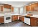 Efficient kitchen featuring wood cabinets, white appliances, and modern vinyl flooring at 6580 N Us Highway 31, Whiteland, IN 46184