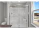Bathroom with step-in shower, toilet, seat, and a large window bringing in natural light and neighborhood views at 6675 Halsey St, Zionsville, IN 46077