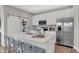 Kitchen island with counter seating, stainless appliances, and open layout to dining area and sliding barn door at 6675 Halsey St, Zionsville, IN 46077
