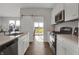 White kitchen featuring stainless appliances, wood-look floors, quartz countertops, and a sliding barn door at 6675 Halsey St, Zionsville, IN 46077