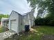 Attached one-car garage exterior with white siding, a partially tarped roof and mature trees nearby at 7607 E 46Th St, Indianapolis, IN 46226