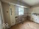 Kitchen interior in need of renovation, featuring an open layout and a window view at 7607 E 46Th St, Indianapolis, IN 46226