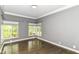Spacious bedroom featuring hardwood floors, natural light, and stylish gray walls and large windows at 7775 N Meridian St, Indianapolis, IN 46260