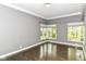 Bright bedroom featuring beautiful hardwood floors, fresh gray paint, and multiple windows for natural light at 7775 N Meridian St, Indianapolis, IN 46260