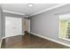 Neutral bedroom with hardwood floors, detailed trim, and a bright window with closet storage space at 7775 N Meridian St, Indianapolis, IN 46260