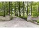 Stone pillars flank an elegant driveway leading through a picturesque tree-lined property at 7775 N Meridian St, Indianapolis, IN 46260
