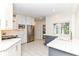 Open floor plan kitchen with marble countertops, white cabinets, stainless steel appliances, and tile flooring at 7775 N Meridian St, Indianapolis, IN 46260