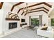Bright living room features vaulted ceilings with exposed beams, a fireplace, and large windows with views of the yard at 7775 N Meridian St, Indianapolis, IN 46260