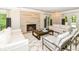 Bright living room with a stone fireplace, hardwood floors, and multiple seating areas with natural lighting at 7775 N Meridian St, Indianapolis, IN 46260