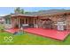 Large red deck off brick home with outdoor cooking and relaxation spaces at 813 Boulder Rd, Indianapolis, IN 46217