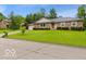 Attractive single-story brick home with a well-manicured lawn and mature trees in a neighborhood setting at 813 Boulder Rd, Indianapolis, IN 46217