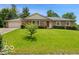 Inviting ranch-style home featuring a brick facade, attached garage, and lush green lawn with mature shrubbery at 813 Boulder Rd, Indianapolis, IN 46217