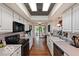 The open kitchen features a light-filled space with white cabinets and views to the sunroom at 813 Boulder Rd, Indianapolis, IN 46217