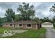 Charming brick home featuring a well-maintained lawn and a detached two car garage at 907 Monroe St, Indianapolis, IN 46229