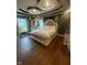 Elegant Primary bedroom featuring hardwood floors, tray ceilings, and a decorative sitting area at 9527 Pepperidge Dr, Indianapolis, IN 46235