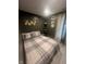 Cozy bedroom with a plaid comforter, dark green walls, and natural light from the window at 9527 Pepperidge Dr, Indianapolis, IN 46235