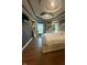Bedroom featuring hardwood floors, tray ceilings, and an elegant sitting area at 9527 Pepperidge Dr, Indianapolis, IN 46235