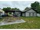 The back of the house and carport are shown with green grass, patio and wet concrete pad at 9527 Pepperidge Dr, Indianapolis, IN 46235