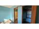 This blue bedroom features wood-look flooring, an ensuite bathroom, and a closet with shelving at 9730 English Oak Pl, Indianapolis, IN 46235