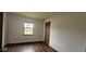 This bedroom has wood-look flooring and a window that overlooks a green, tree-filled view at 9730 English Oak Pl, Indianapolis, IN 46235