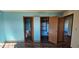 This bedroom features blue walls, wood-look flooring, and a private entrance to the ensuite bathroom at 9730 English Oak Pl, Indianapolis, IN 46235