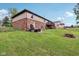 Backyard view with a deck, a patio set, a brick house, and a play area for children at 976 Santa Maria Dr, Greenwood, IN 46143
