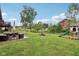 Spacious backyard with a patio set, fire pit, play set, and lush lawn at 976 Santa Maria Dr, Greenwood, IN 46143