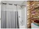 Bathroom featuring wood accent wall, shower-tub combo with a gray patterned shower curtain at 9771 Blue Violet Dr, Noblesville, IN 46060