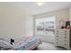 Bright bedroom with a twin bed, white dresser, neutral walls and a large window at 9771 Blue Violet Dr, Noblesville, IN 46060