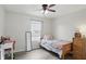 Sunlit bedroom featuring hardwood floors, a cozy bed, and a dedicated study space with a desk at 9771 Blue Violet Dr, Noblesville, IN 46060