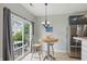 Cozy breakfast nook with a round table, pendant lighting, and sliding glass doors to the backyard at 9771 Blue Violet Dr, Noblesville, IN 46060