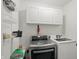Efficient laundry room with modern appliances, overhead storage, and practical shelving at 9771 Blue Violet Dr, Noblesville, IN 46060