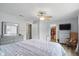 Spacious main bedroom featuring a ceiling fan, walk-in closet, TV, and light colored, wood-look floors at 9771 Blue Violet Dr, Noblesville, IN 46060