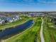 Panoramic aerial view of a community featuring a golf course, pond, and clubhouse at 987 Oak Terrace Rd, Westfield, IN 46074