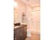 Stylish bathroom featuring a tiled shower, vanity with dark cabinets, and decorative shelving at 987 Oak Terrace Rd, Westfield, IN 46074