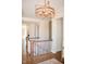 Hallway with hardwood floors, a staircase, and an elegant light fixture creating a warm and welcoming ambiance at 987 Oak Terrace Rd, Westfield, IN 46074