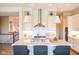 A gourmet kitchen features white cabinets, quartz countertops, and stainless steel appliances and vent at 987 Oak Terrace Rd, Westfield, IN 46074