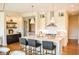 A chef's kitchen shows seating at island, stainless vent hood, white cabinets and open floorplan at 987 Oak Terrace Rd, Westfield, IN 46074