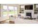 A living room has ample seating with a fireplace, built-ins, and large windows overlooking a pond at 987 Oak Terrace Rd, Westfield, IN 46074