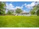 Wide backyard view showing lush greenery, the home's exterior, and surrounding trees at 10097 N Balfer E Dr, Fortville, IN 46040